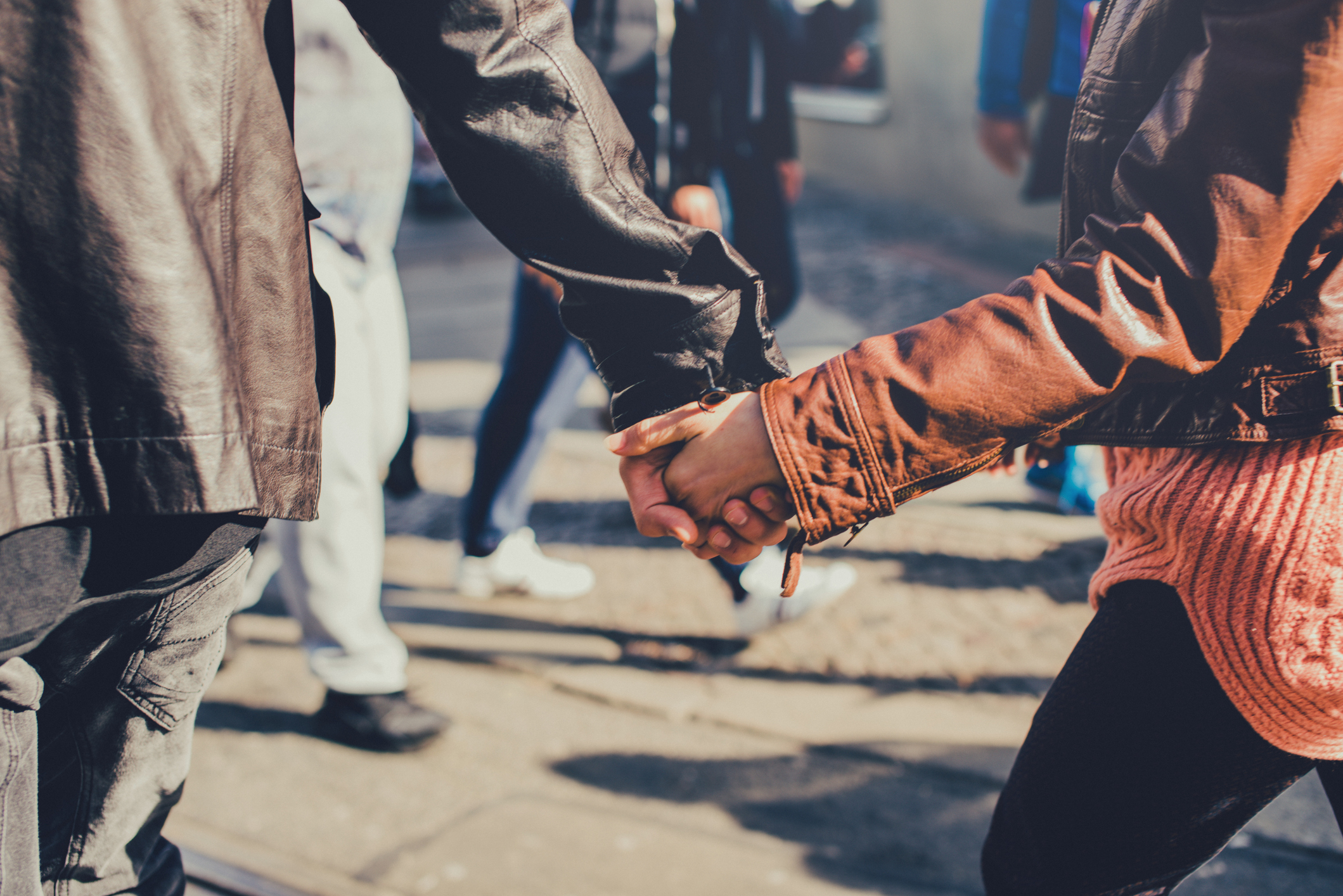 Young couple going hand in hand through the street.