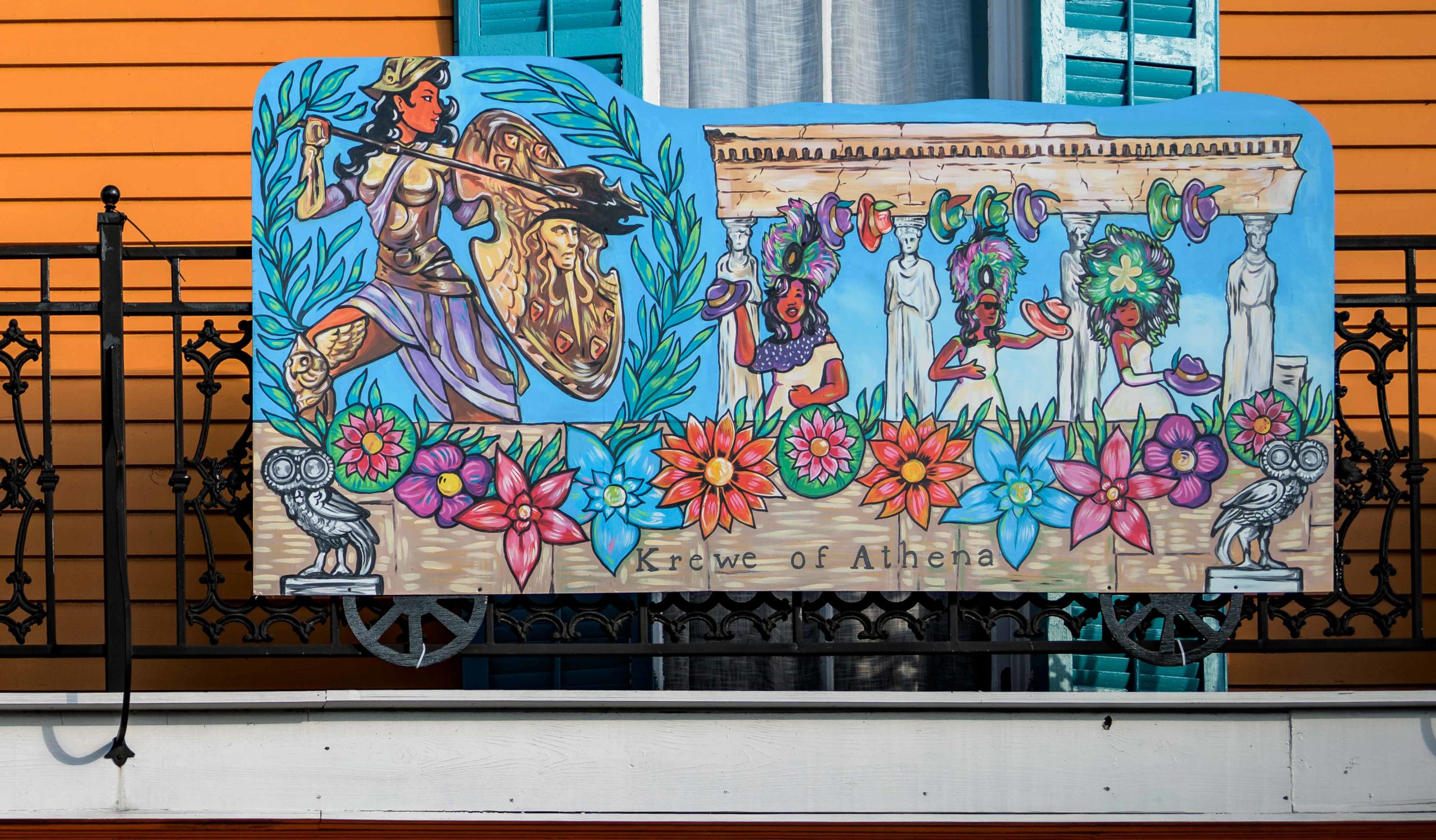 The Stronghold Studios, @strongholdstudios, a New Orleans entertainment display and prop company, has created a full Carnival parade house float on the balcony @The_Marigny_Stoop seen here on Sunday, January 16, 2022. Formerly the home to the American Baking Co. in the early 1900s, the house on 2501 Chartres St has been painted a bright orange by Dr. Maurice Sholas. The adult themed Krewe du Vieux passes by the home and Sholas hosts the “Doc Mo Sho’s Krewe du Vieux Extravaganza” along the parade route. The Marigny House Float balcony includes a styrofoam painted sculpture of Monogram Hunters Second Chief Jeremy Stevenson, and painted boards of Mardi Gras floats from the Zulu Social and Pleasure Club and the Rex Organization, and floats from female Carnival krewes including the Mystic Krewe of Femme Fatale, the Krewe of Athena, and the shoe-decorating Krewe of Muses. The house float tradition began last year in 2021 when Mardi Gras was canceled due to the COVID-19 pandemic. Hopefully there will be a Mardi Gras this year with actual floats, but if not there will be plenty of house floats to drive past at a safe social distance. Photo by Matthew Hinton