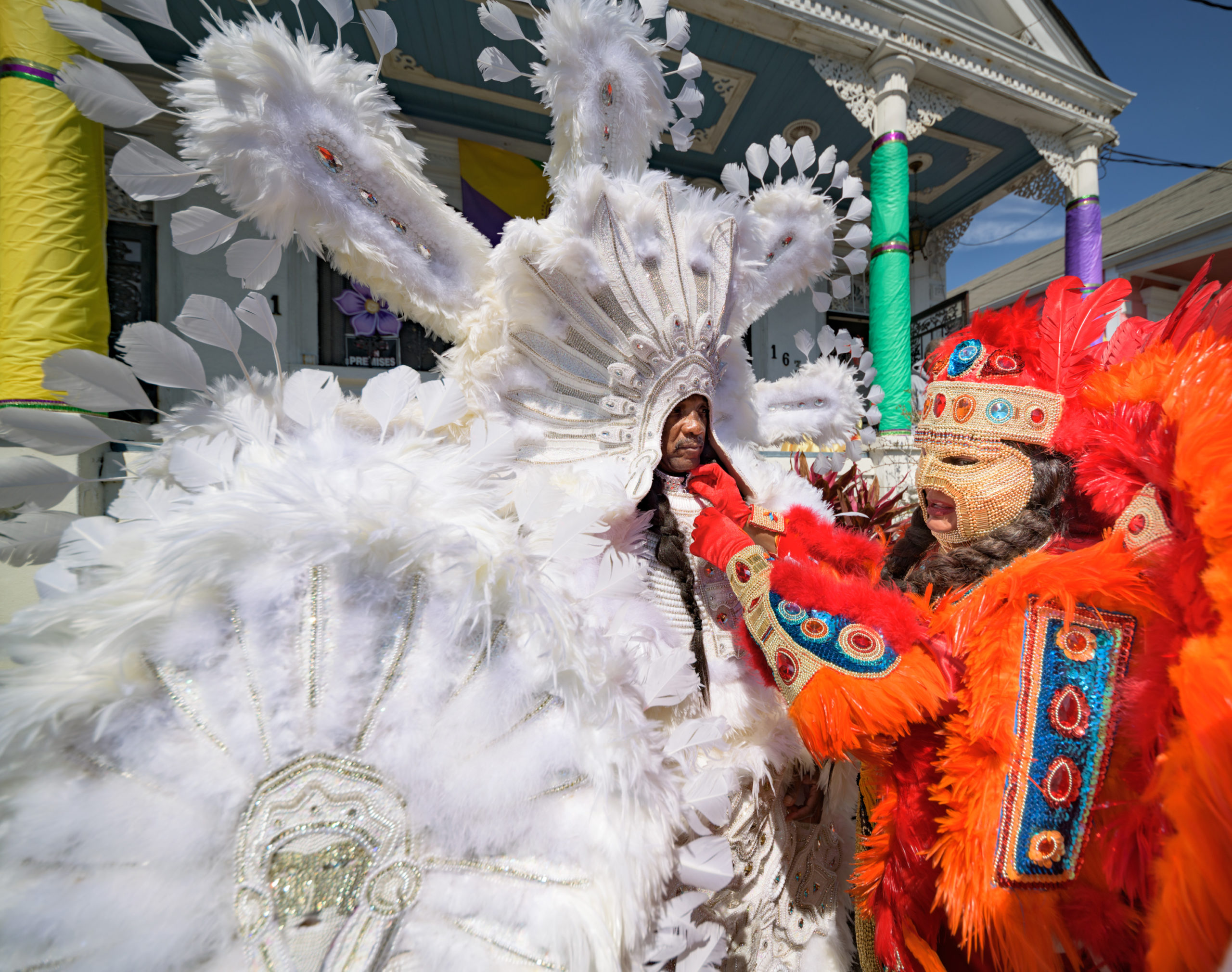 Yellow Pocahontas Queen Dianne Honore, right, helps Big Chief Darryl Montana put on his suit for Mardi Gras, March 1, 2022 in New Orleans in front of the home of Darryl’s father, Big Chief “Tootie” Montana. Photo by Matthew Hinton