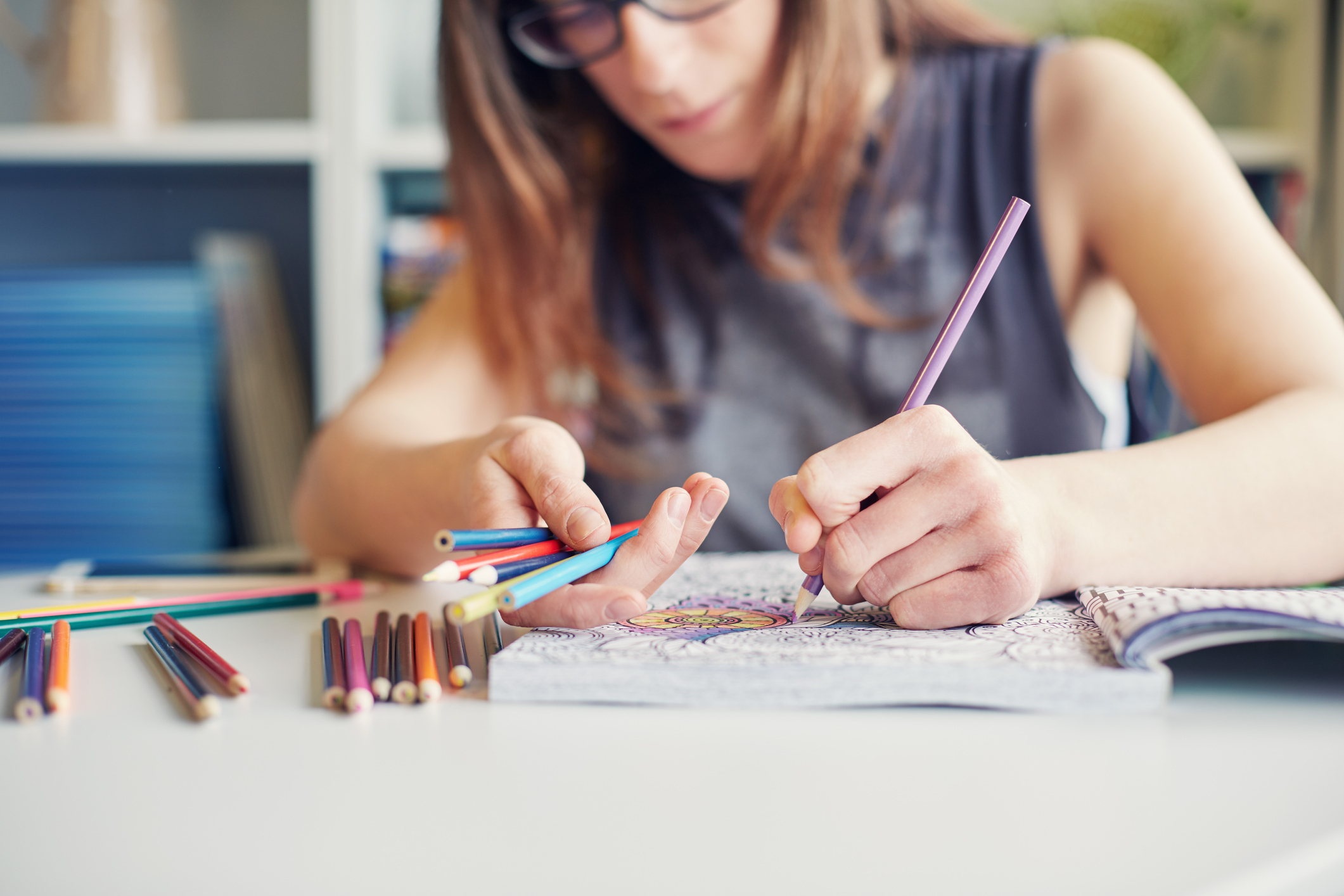 Young woman colouring in an adult colouring in book