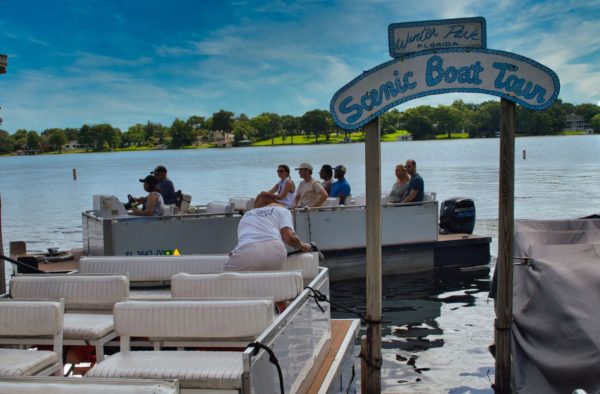 Tourists return to the dock of the Winter Park Scenic Boat tour after enjoying a day out on the water of the Winter Park chain of lakes.