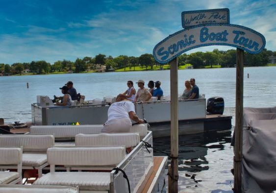 Tourists return to the dock of the Winter Park Scenic Boat tour after enjoying a day out on the water of the Winter Park chain of lakes.
