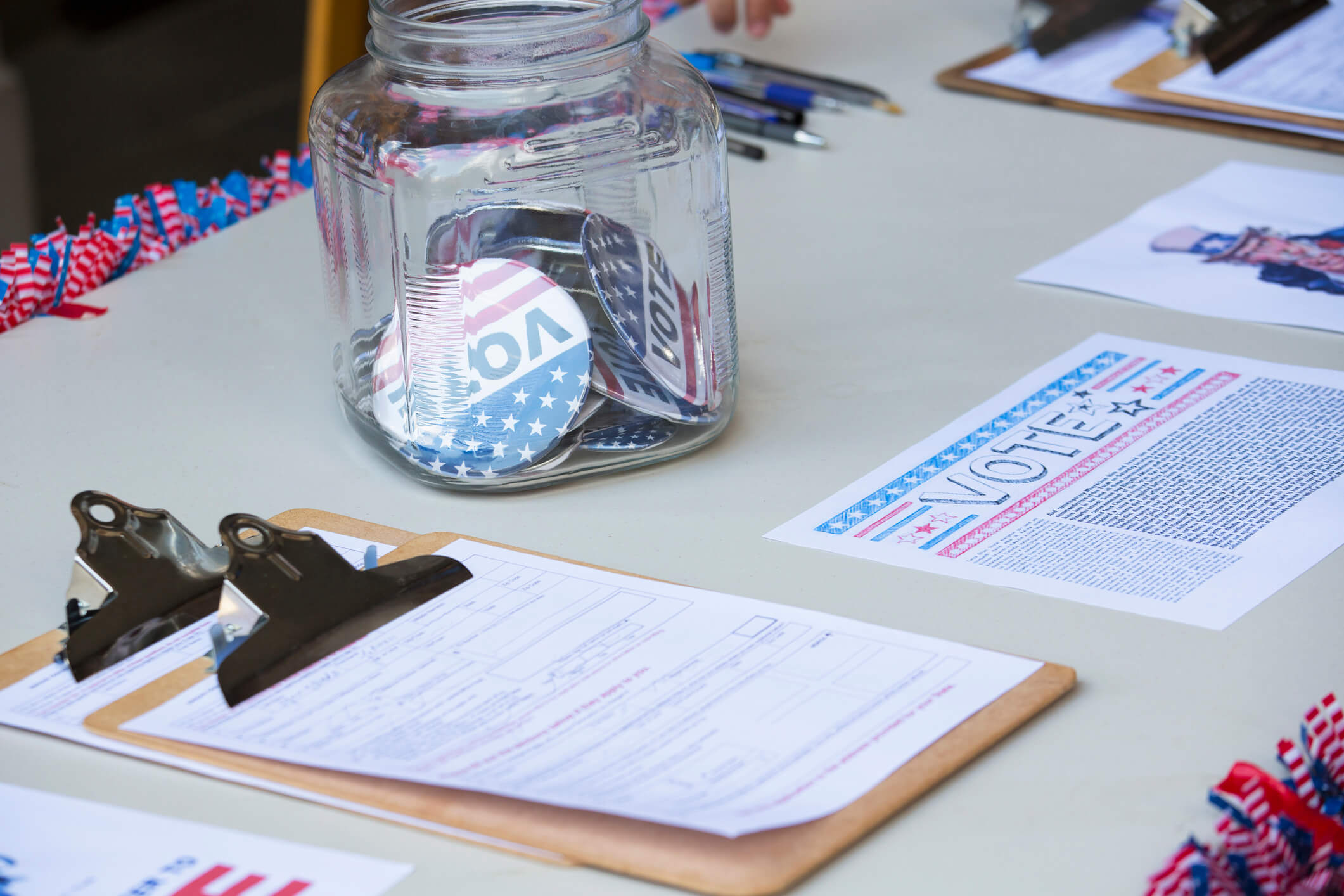 Clipboards and buttons at voter registration table