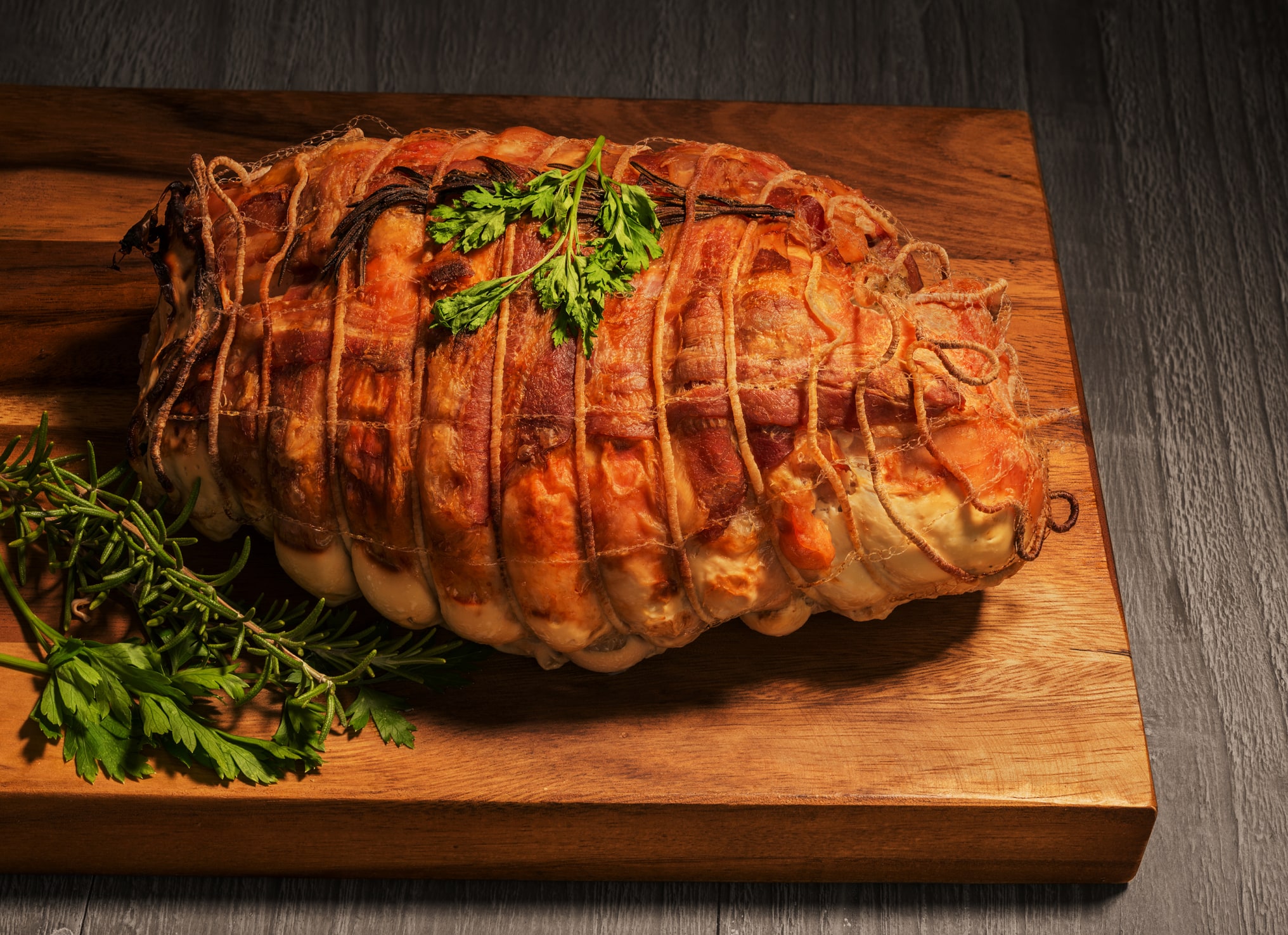 Turkey meat,chicken breast and duck fillet, stuffed with fig and pistachios, wrapped in bacon and garnished with fresh rosemary roasted as Christmas dish