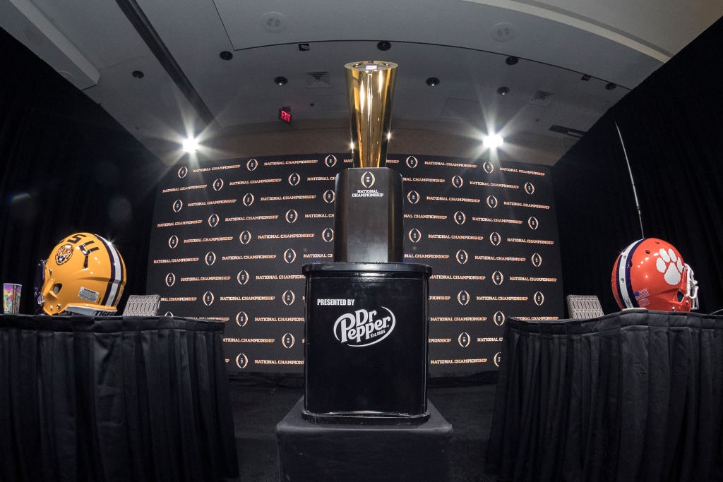 NEW ORLEANS, LOUISIANA - JANUARY 12:  A general view of The College Football Playoff National Championship Trophy with both LSU Tigers and Clemson Tigers helmets on both sides before the start of the Head Coaches Press Conference before the College Football Playoff National Championship at the Grand Ballroom at the Sheraton Hotel on January 12, 2020 in New Orleans, Louisiana. (Photo by Don Juan Moore/Getty Images)