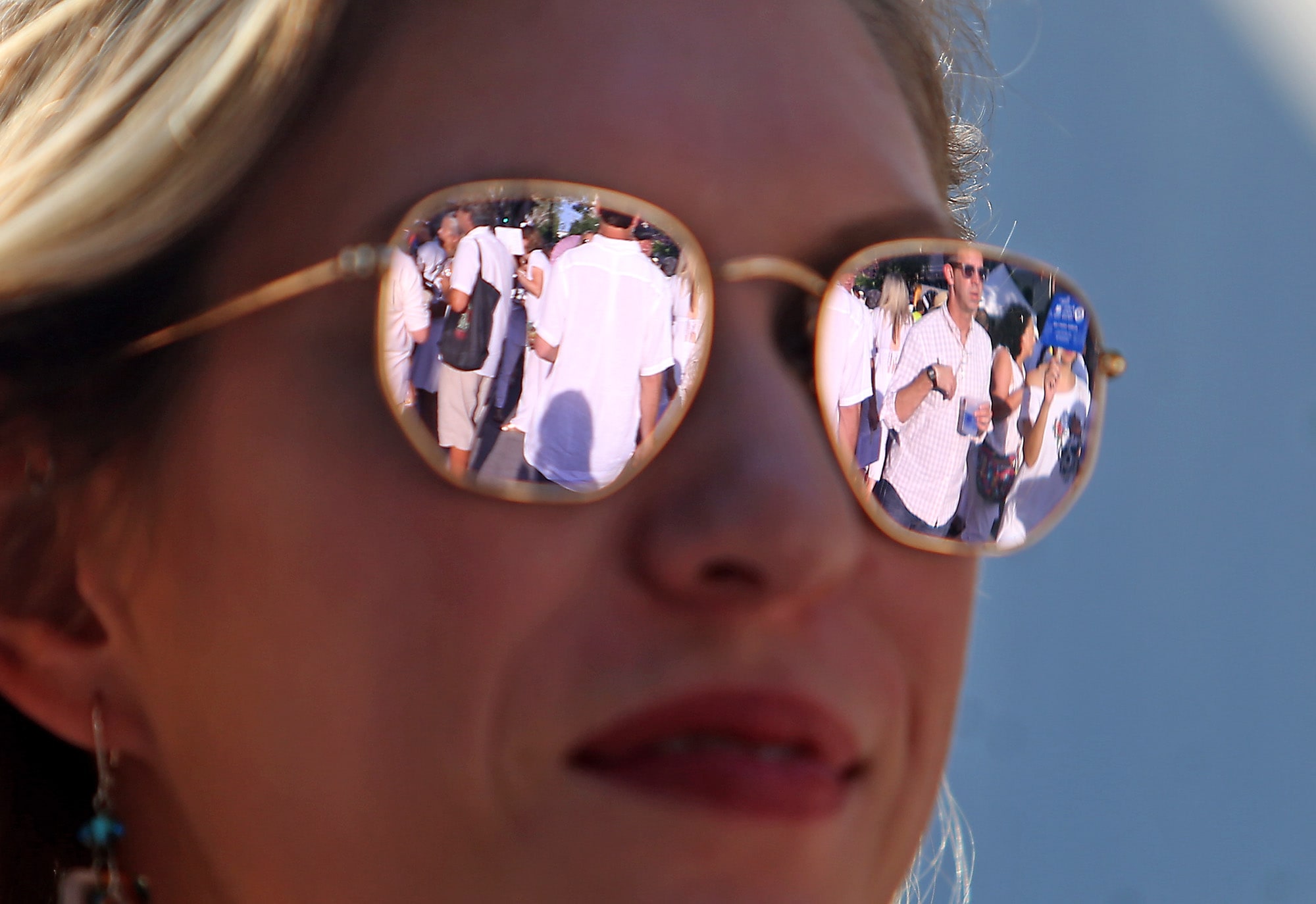 Art lovers strolling Julia Street are reflected in sunglasses during the 25th annual Hancock Whitney White Linen Night in the 300 to 700 blocks of Julia Street as well as other venues around the Arts District New Orleans. The free block party featured live music, food and drink from over thirty local vendors, gallery openings, and displays of public art, all benefiting the Contemporary Arts Center.