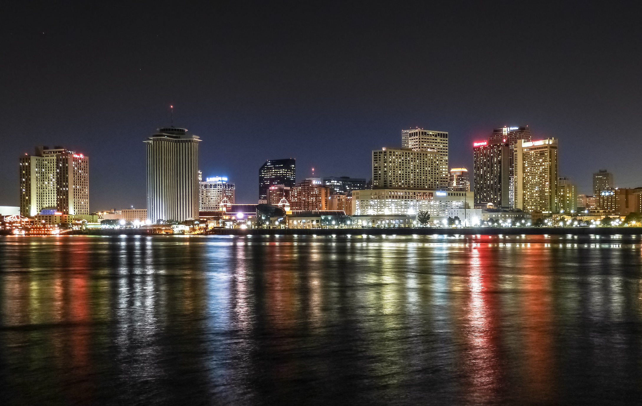 Majestic New Orleans skyline illuminated at late dusk with reflection on Mississippi river in Louisiana, USA