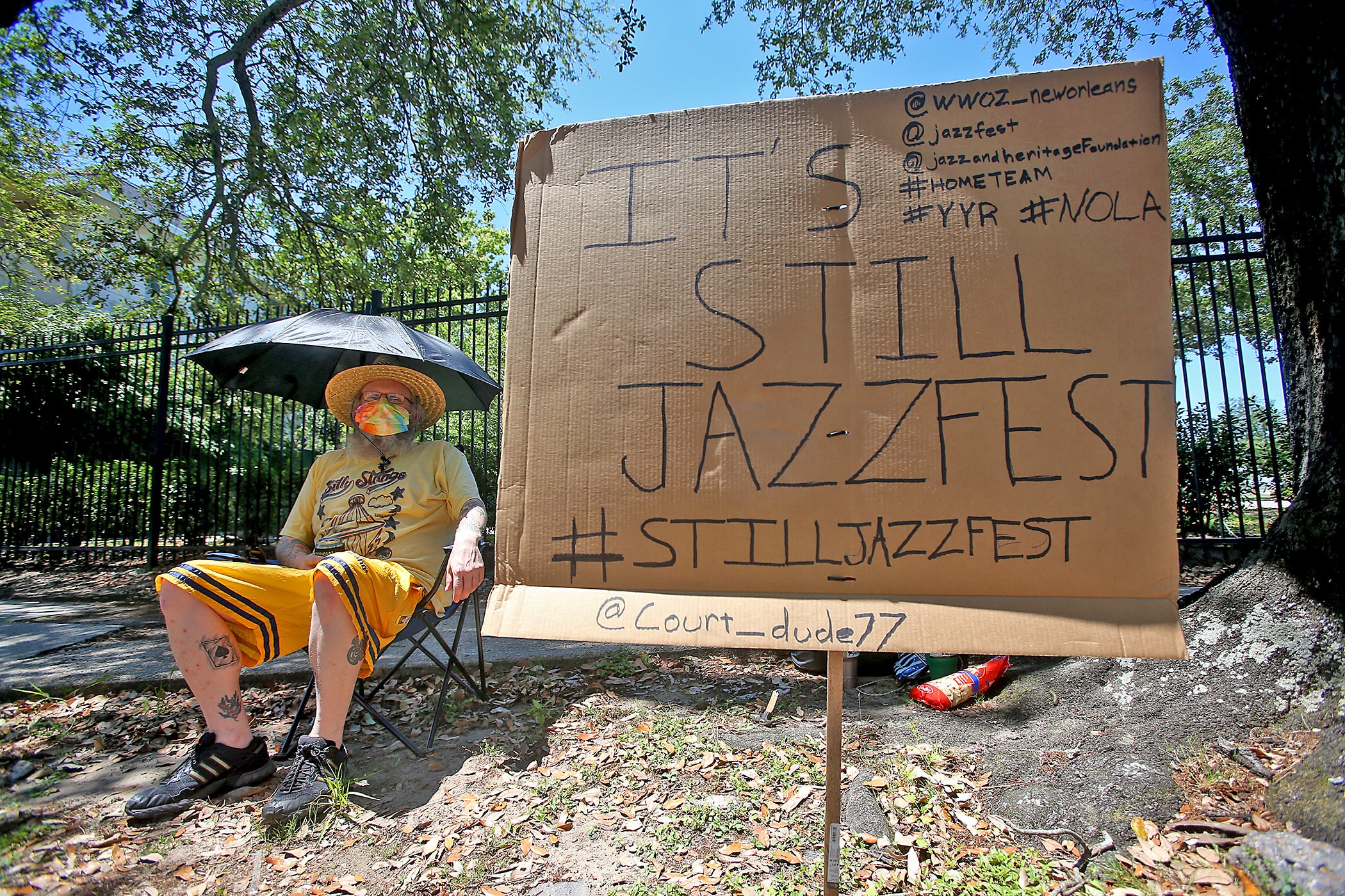 Courtney McColloch is determined the show must go on as he listens to the WWOZ broadcast outside the shuttered gates of the Fair Grounds after the 2020 New Orleans Jazz &amp; Heritage Festival was cancelled by the Covid-19 pandemic. Photographed on Friday, April 24, 2020. (Photo by Michael DeMocker)