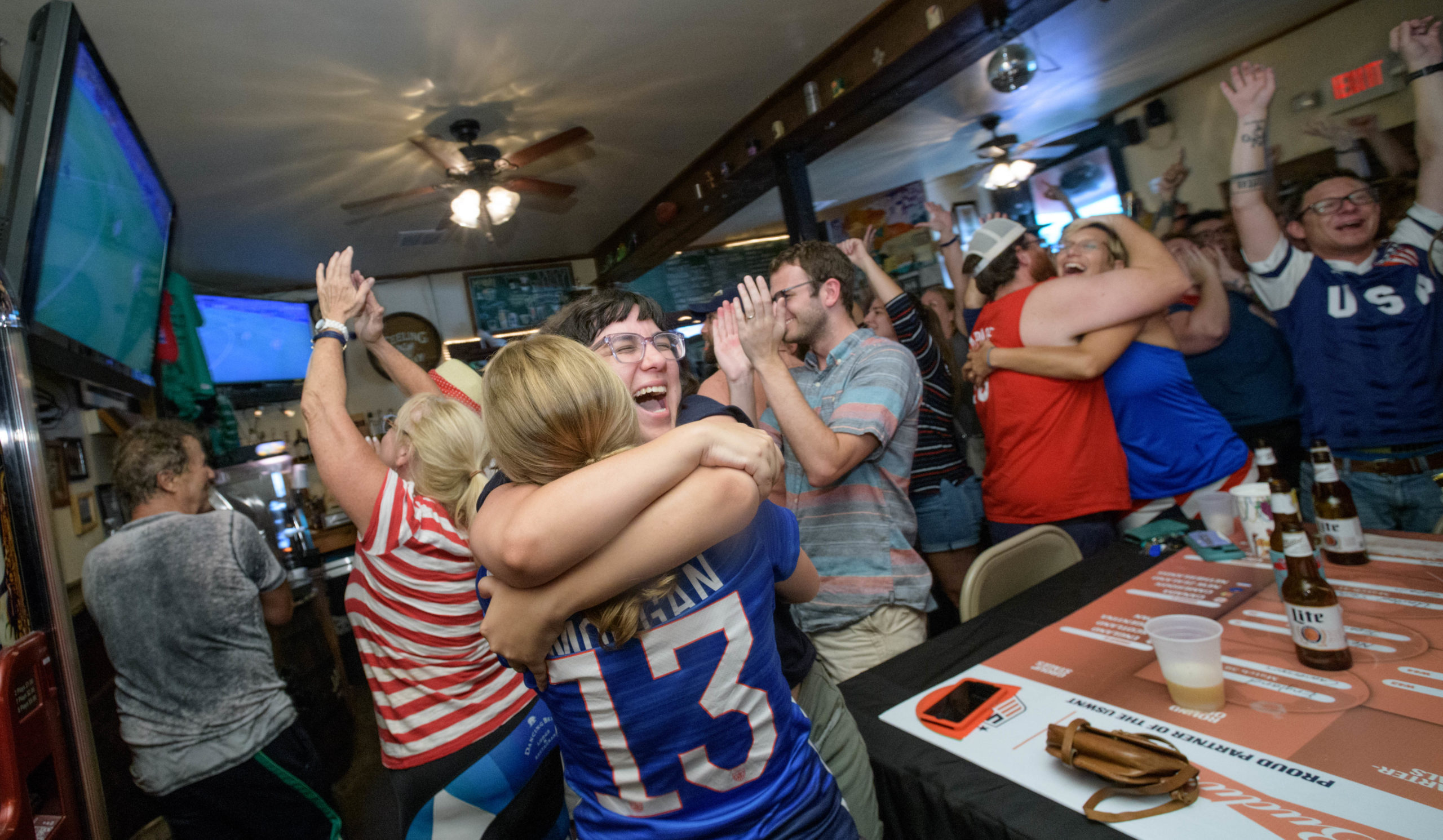 Patrons including Stephanie Oshrin, wearing Alex Morgan's #13 jersey, and Jessica Nicholls celebrate at Finn McCool's Irish Pub in the Mid-City neighborhood of New Orleans as the U.S. Women's National Soccer Team's completes a 2-0 victory over the Netherlands in the Women's World Cup in France Sunday, July 7, 2019. Photo by Matthew Hinton