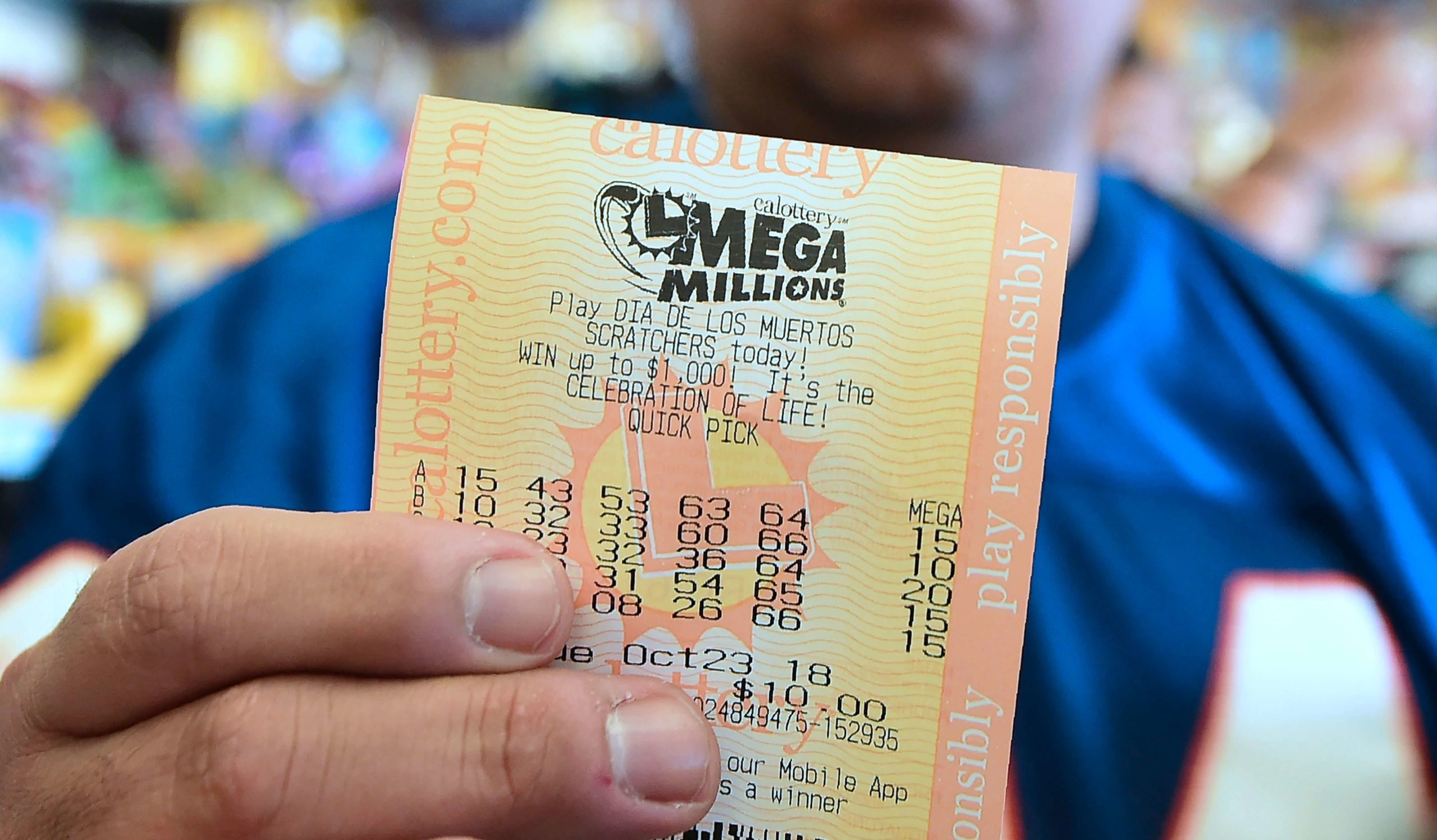 A man shows his just purchased lottery tickets from the Blue Bird Liquor store in Hawthorne, California on October 23, 2018 ahead of the drawing tonight for the Mega Millions jackpot, now reaching USD 1.6 billion. (Photo by Frederic J. BROWN / AFP)        (Photo credit should read FREDERIC J. BROWN/AFP/Getty Images)