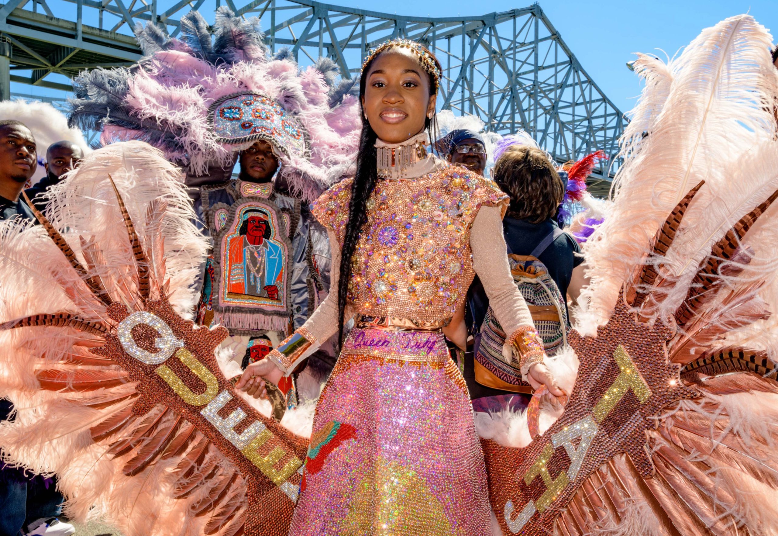 Second Queen Tahj Williams of the Golden Eagles Mardi Gras Indians stands near the Crescent City Connection Bridges that bring traffic to the West Bank during the West Bank Super Sunday in the Algiers neighborhood in New Orleans, La. Sunday, April 14, 2019. Photo by Matthew Hinton