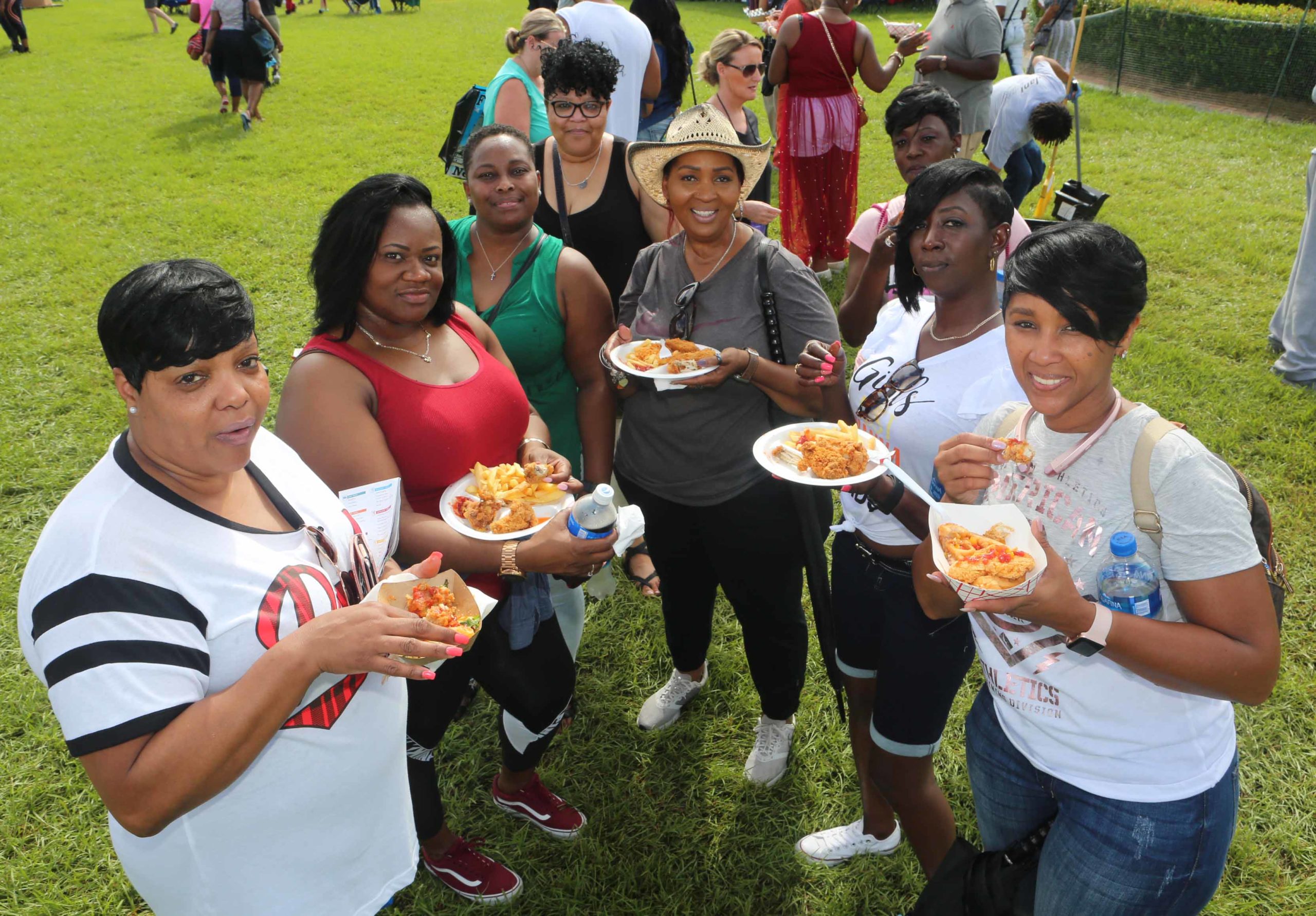 A group of ladies pose while eating some fried chicken during the National Fried Chicken Festival at Woldenberg Park in New Orleans on Saturday, September 22, 2018.  (Photo by Peter G. Forest)  Instagram:  @forestphoto_llc