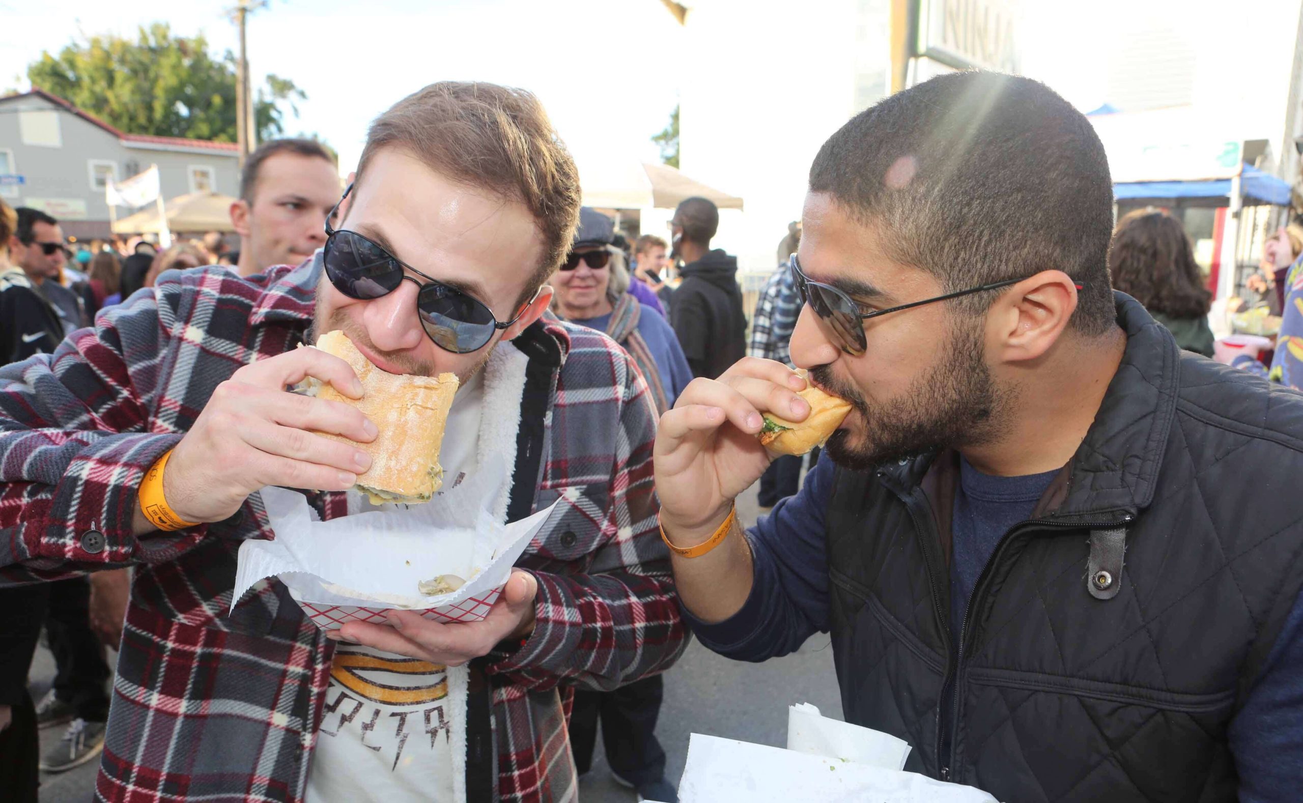 Christos Eraclides and Fahad Albaijan both eat some po-boys during the Oak Street Po-Boy Festival in New Orleans on Sunday, November 11, 2018.  (Photo by Peter G. Forest)