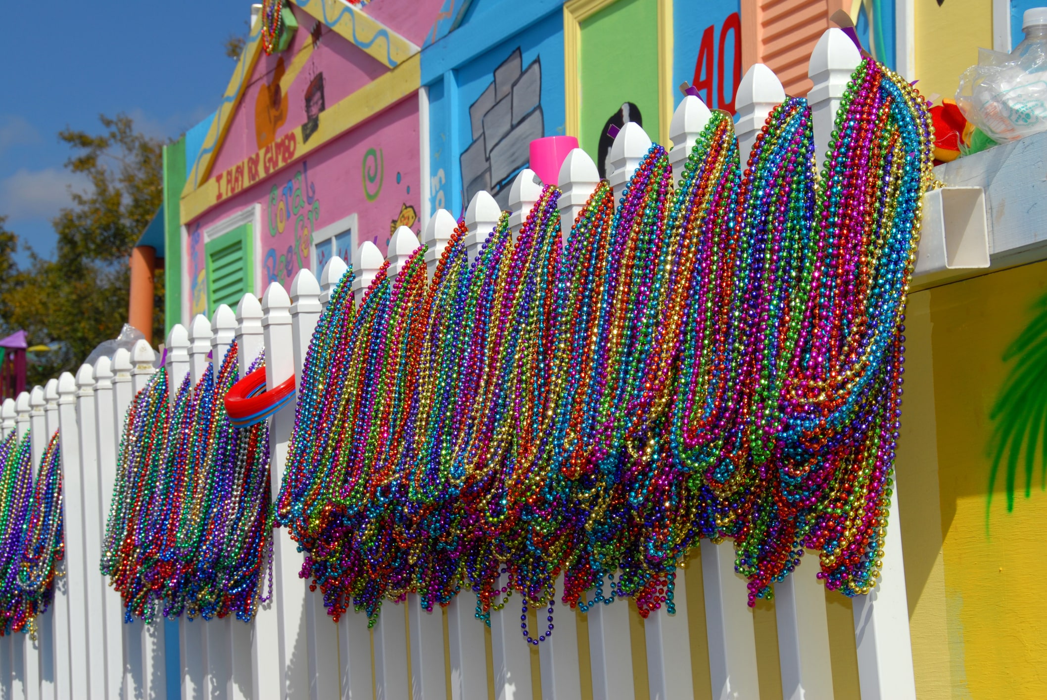 A shot taken in Penscola, Florida, a few hours before the start of the downtown Mardi Gras parade in 2007.  The ready nature of these beads, contrasted in a quiet and isolated moment, seem to just beckon for a photograph.  Needless to say, hours later these beads were spread all over downtown amongst participants, sidewalks, balconies, and even in trees and on lamp posts!