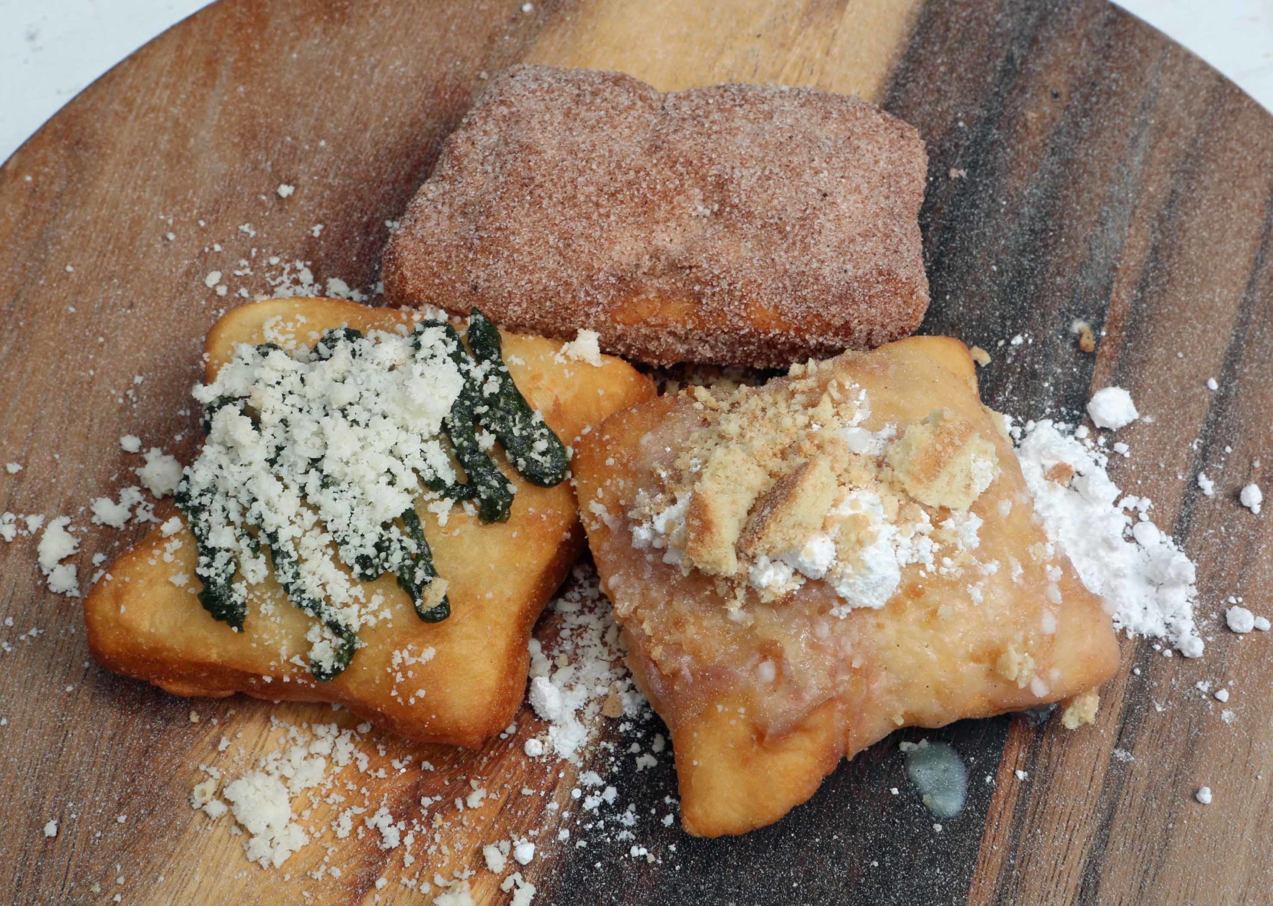 A trio of beignets (clockwise from left) Cilantro Pesto, Churro and Banana Pudding beignets courtesy of Southern Grit Flavor during the Beignet Festival at the City Park Festival Grounds in New Orleans on Saturday, October 6, 2018.  (Photo by Peter G. Forest)  Instagram:  @forestphoto_llc