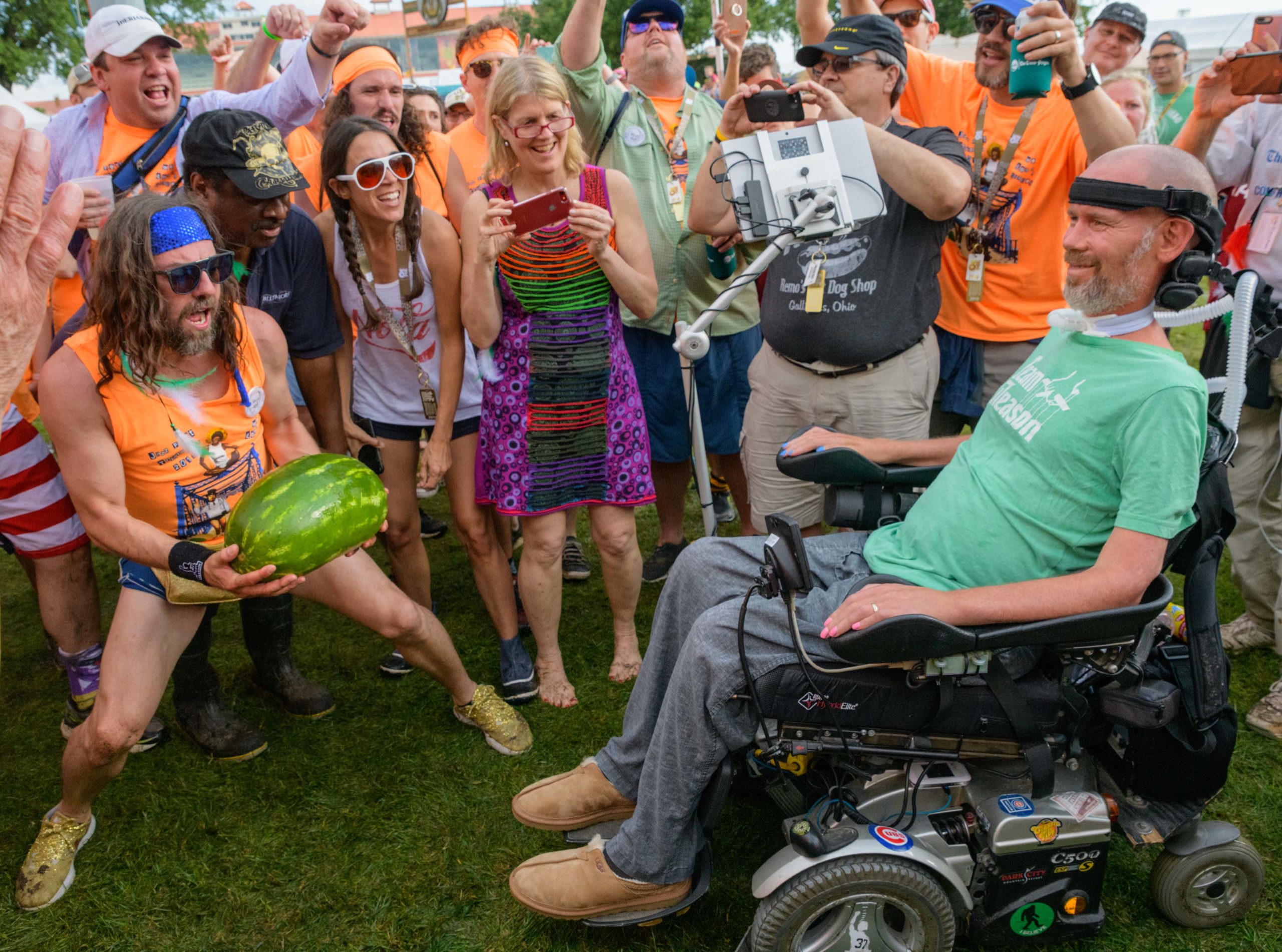 The members of the Cabrini Dad's Club, Tu-Tu Man, and Mick Jaggar (sic) present the 20th Jazz Fest Triathlon watermelon sacrifice to former New Orleans Saints legend and ALS advocate Steve Gleason at the Fais Do Do Stage at Jazz Fest on Locals Thursday in New Orleans, La. Thursday, April 25, 2019. The annual triathlon begins in Bayou St. John with a bicycle race followed by the watermelon sacrifice, then a run, and swim again in Bayou St. John. Photo by Matthew Hinton