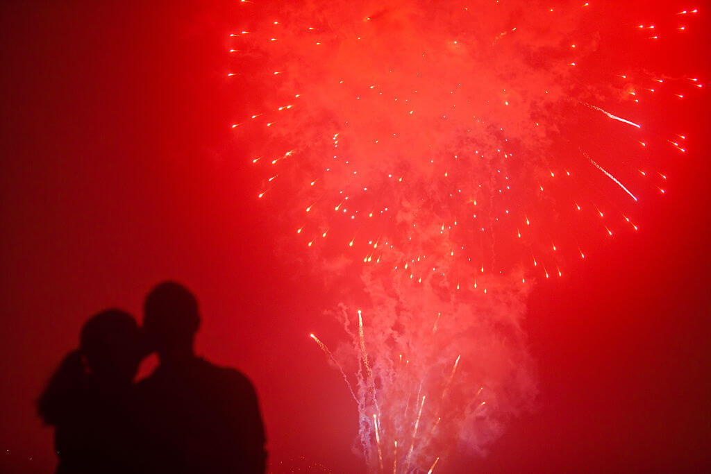 A couple shares a romantic moment as fireworks light up the sky over the Mississippi River in the French Quarter of New Orleans, on New Year's Eve. New Orleans has been rated one of the ten best cities to ring in the new year. (Photo by Julie Dermansky/Corbis via Getty Images)