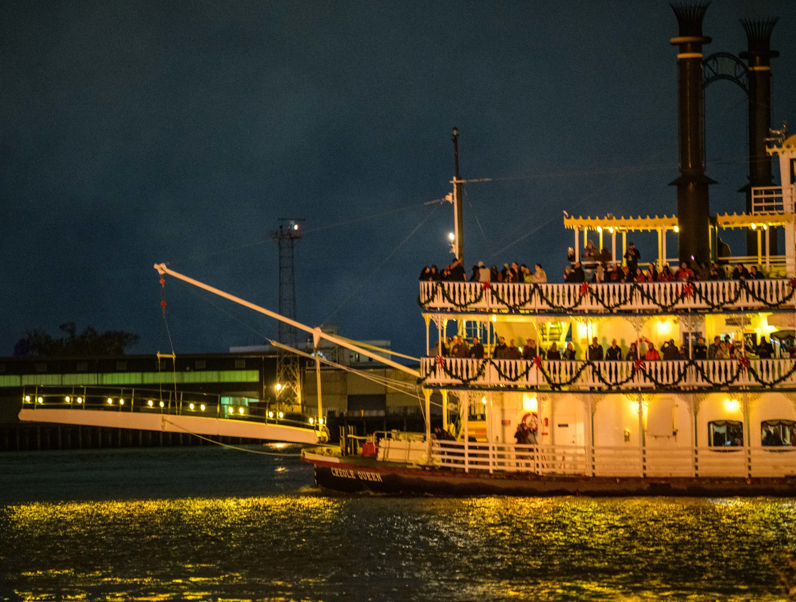 The annual Algiers Bonfire featured a sculpture based on a traditional German Christmas Pyramid Carousel decoration powered by a windmill on top with spinning reindeer and stars at the Algiers Ferry Landing along the West Bank of the Mississippi River in New Orleans, Saturday, Dec. 7, 2019. The sculpture was designed by NOLA Burners including artist Eric Arvidson and Brennan Steele. The CBD (Central Business District not that other CBD stuff) and the French Quarter including St. Louis Cathedral could be seen across the river on the East Bank. The L.B. Landry-O.P. Walker High School Marching band played before the fire sponsored by the Algiers Economic Development Foundation. A horned devil or possibly Krampus was sighted admiring the flames along with a lady with reindeer antlers. The river was only at 9 feet during the bonfire, which is nearly half the height it was at in May 2019 when the river crested to 17.25 feet and Flood Stage. When the river was at or near flood stage all this landing area behind the river levee was completely submerged including some barricades used for the bonfire. Bonfire traditions along the river around Christmas time are meant to lead Santa Claus or Papa Noel to homes along the river. The largest bonfires occur on Christmas Eve in St. James Parish along the river levee in the towns of Gramercy, Paulina, and Lutcher. Photo by Matthew Hinton.