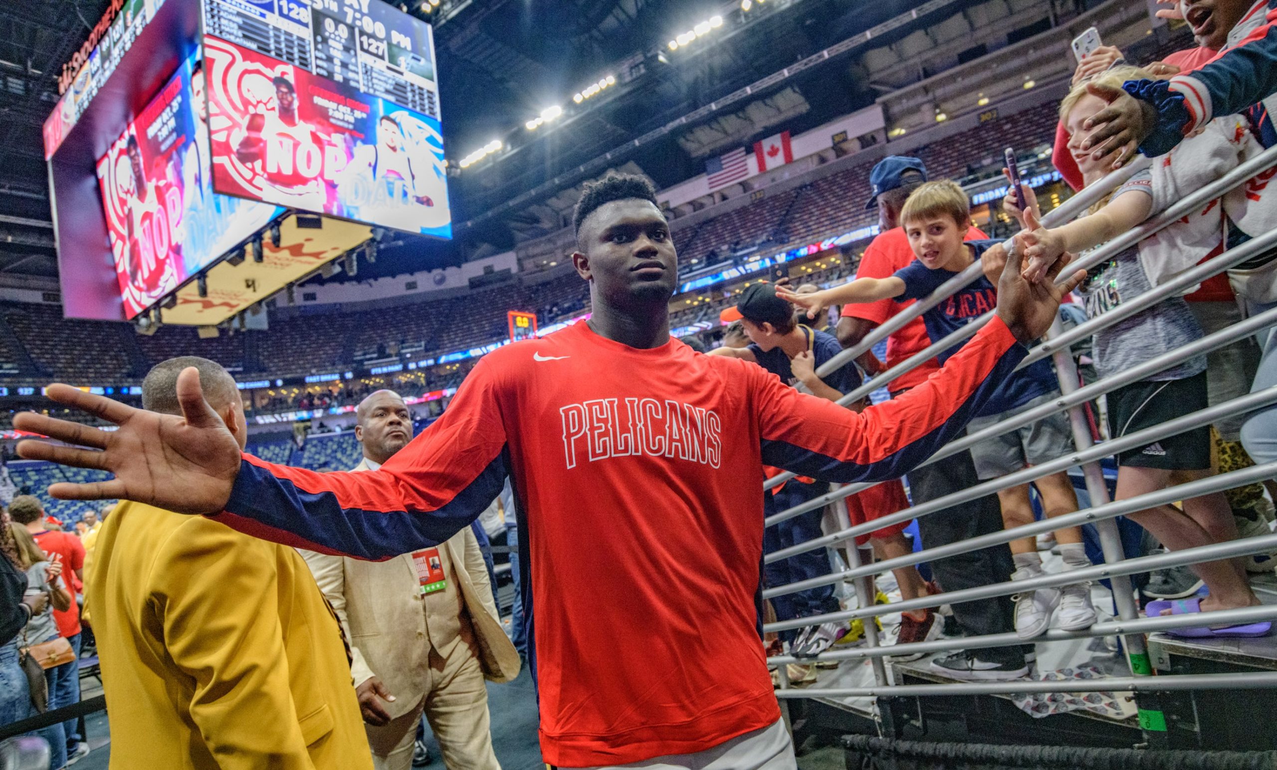 New Orleans Pelicans forward Zion Williamson (1) high-fives fans as he leaves as the top scorer with 26 points in his teams 128-127 victory over the Utah Jazz in New Orleans, Friday, Oct. 11, 2019. Williamson, the number one pick in the NBA draft, made his home debut during the preseason game at the Smoothie King Center. Photo by Matthew Hinton