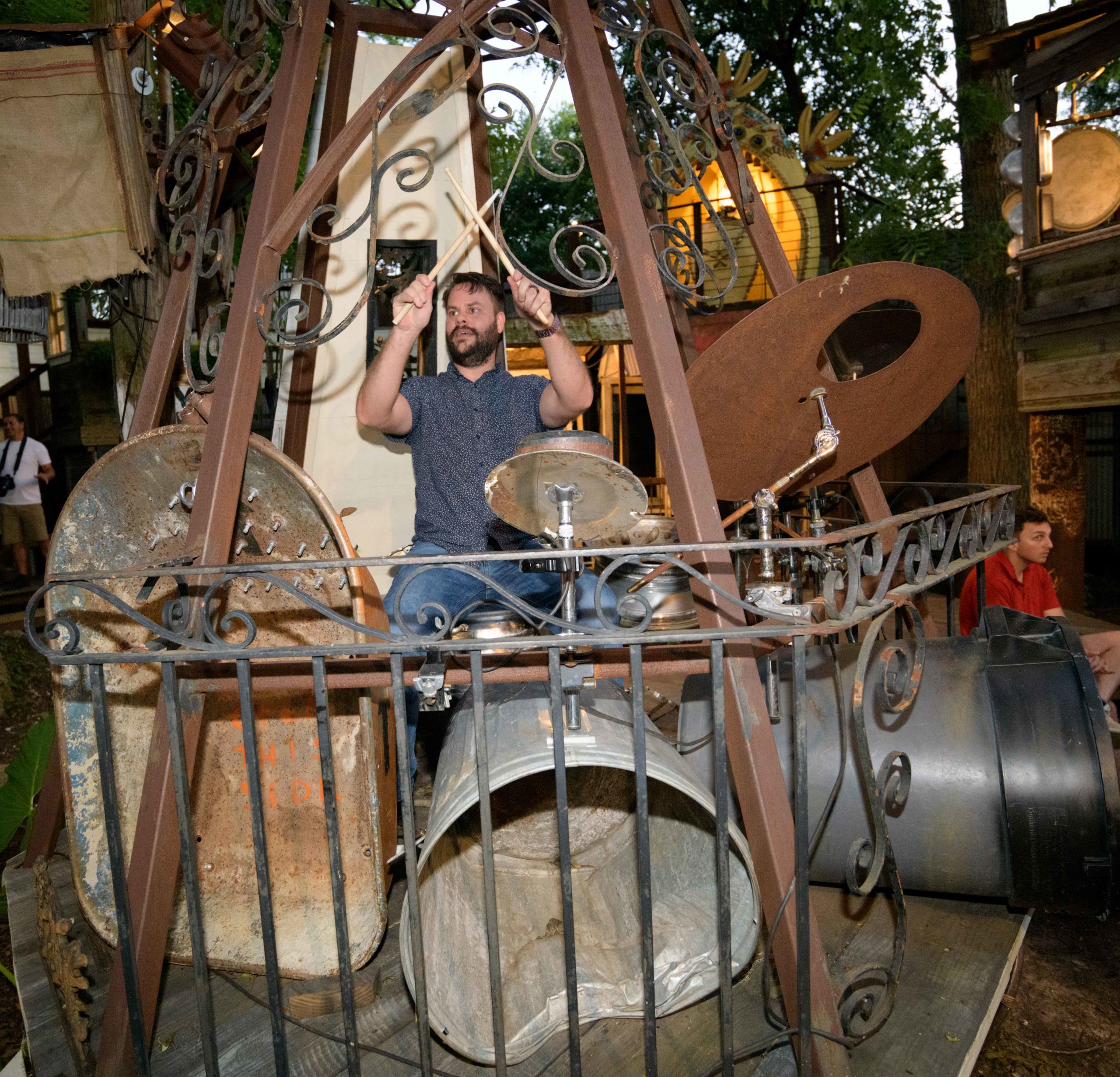 David Welch plays on the Drum Rose and Junkit that mimics a drum set with various pieces of junk including a wheel barrow and trash can on the opening night of 'Elevator Pitch' at Music Box
Village in New Orleans, La. Tuesday, May 21, 2019. A button marked 'David' is one of the screaming voices that can be heard in the 'Elevator Pitch' art piece as one of the deaf voices of Louisiana. Photo by Matthew Hinton