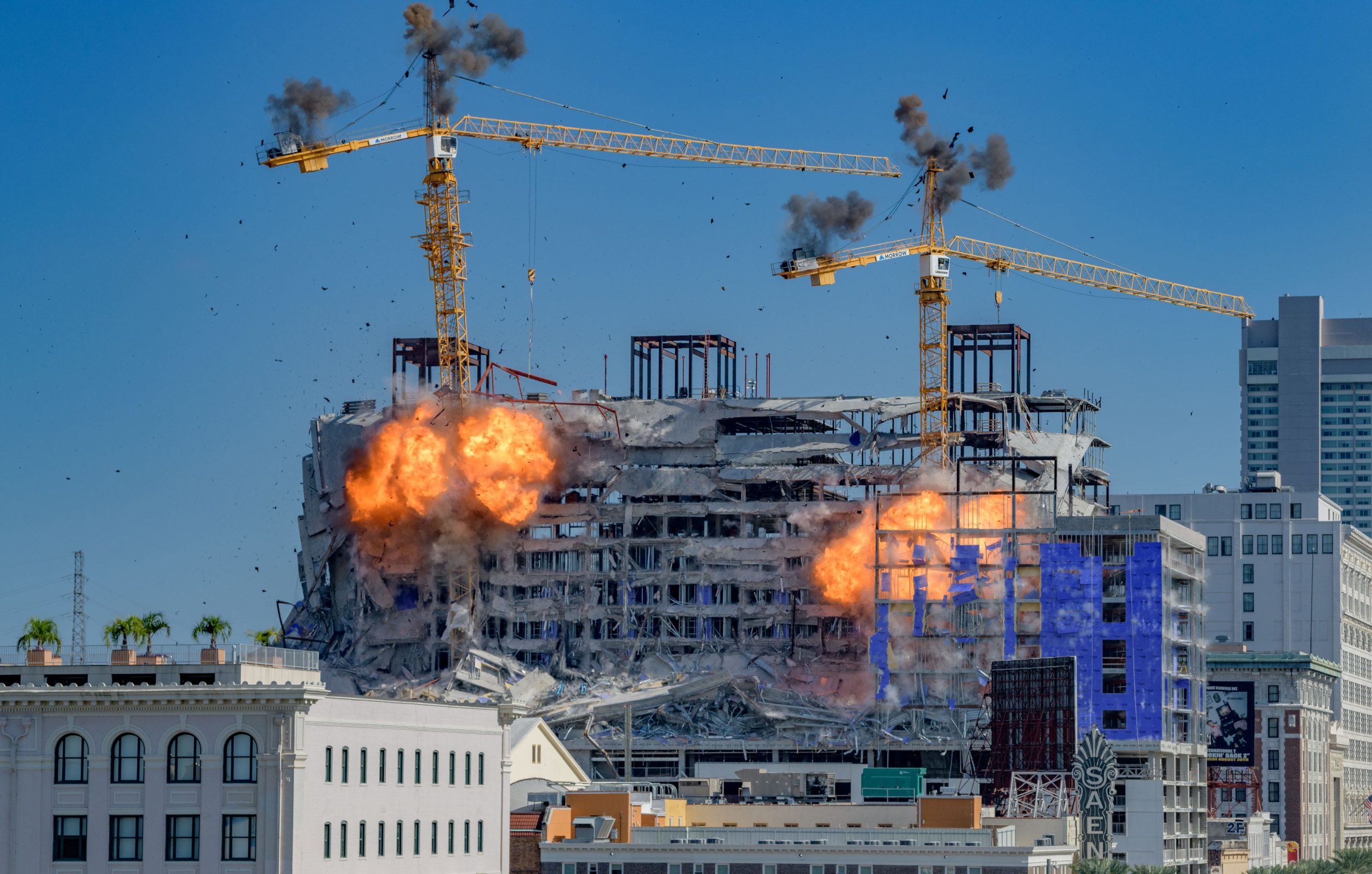 Two cranes begin to come down after a demolition implosion at the Hard Rock Hotel collapse site in New Orleans Sunday October 20, 2019. Three people died and at least 20 were injured in the initial collapse on Saturday October 12th. No one was injured Sunday when the demolition caused one of the two cranes to land in the street below. A sewer line was damaged but the buried gas and electrical lines were not damaged according to city officials. The historical Saenger Theatre did not sustain major damage at the crane collapse with the crane just missing the theater. The crane was already leaning after the initial collapse and would have likely fallen down in the next few days without a planned demolition. Photo by Matthew Hinton