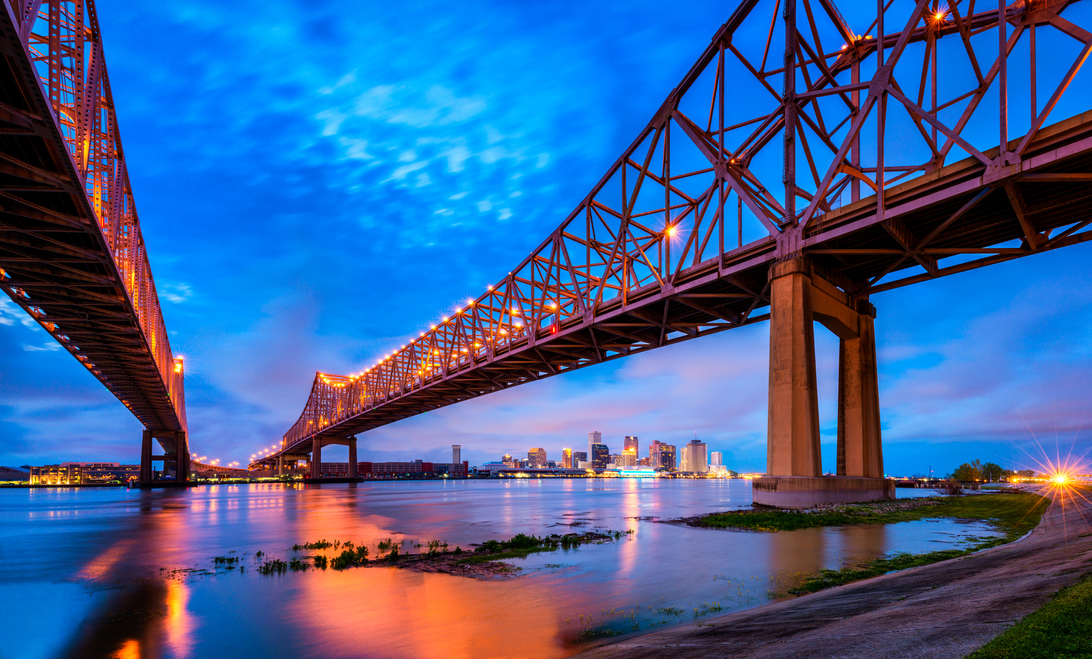 Skyline of New Orleans with Mississippi River and Crescent City Connection Bridge at Dusk, Louisiana, United States.