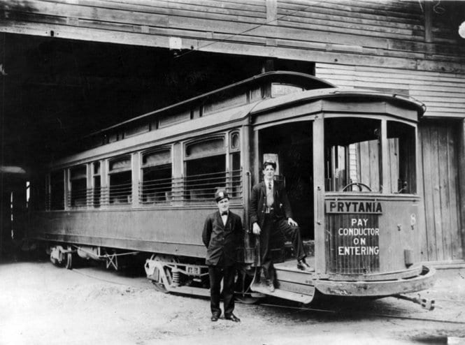 Prytania streetcar line, 1907. Two uniformed men stand by entrance, presumably the motorman and the conductor. Streetcar is at a carbarn, likely the Prytania barn. Courtesy of Wikipedia. 