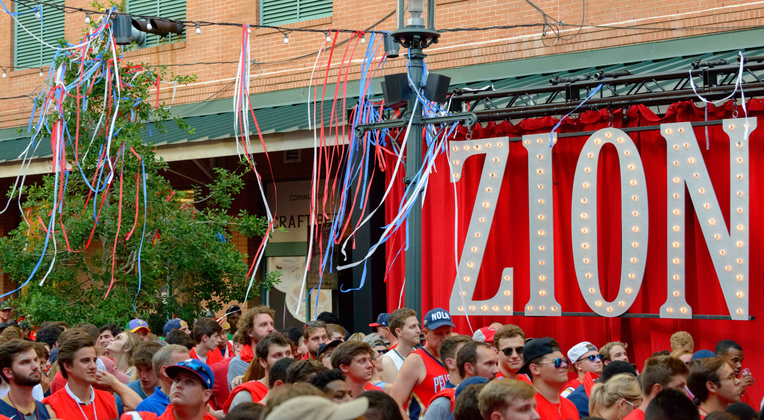 Fans hang out in Fulton Square during the announcement of the New Orleans Pelicans drafting Zion Williamson number one in the NBA draft outside Manning's Restaurant in Fulton Square in New Orleans, La. Thursday, June 20, 2019. Manning's is run by Archie Manning, the first round draft pick of the New Orleans Saints in 1971 and the father of two number one NFL draft picks with his sons Eli and Peyton Manning who were both born in New Orleans. Photo by Matthew Hinton