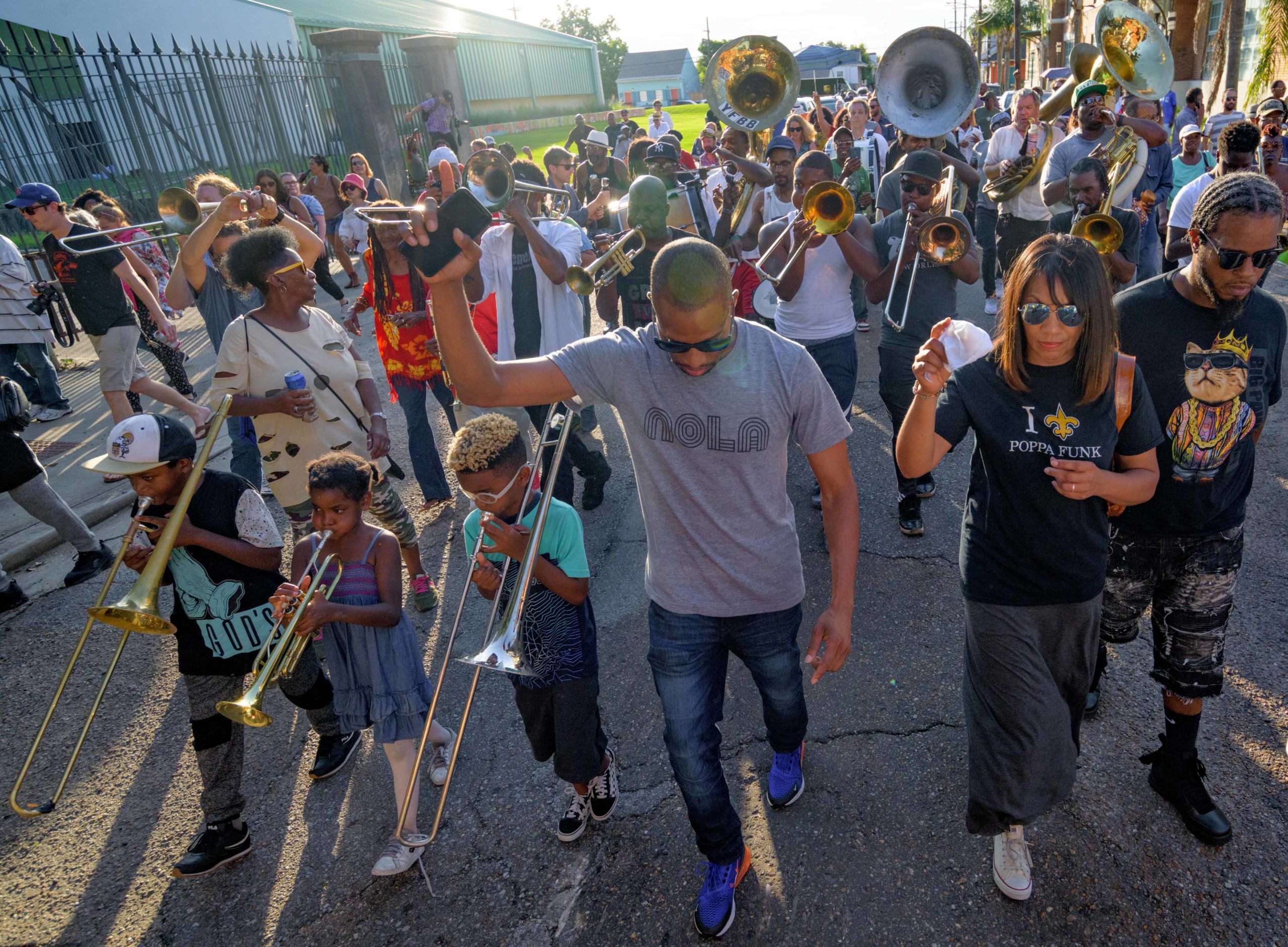 A brass band parades in memory of Art Poppa Funk Neville in the Treme neighborhood lead by Treme trombonist Corey Henry, top left, in New Orleans, Monday, July 29, 2019.  Arthur Lanon Neville (December 17, 1937  July 22, 2019) was known for New Orleans standards Hey Pocky A-Way, Fire on the Bayou, and Mardi Gras Mambo. He was a pioneer of funk and New Orleans music, and was best known as the keyboardist and songwriter for the Grammy-winning Neville Brothers and Rock and Roll Hall of Fame nominated The Meters. Photo by Matthew Hinton