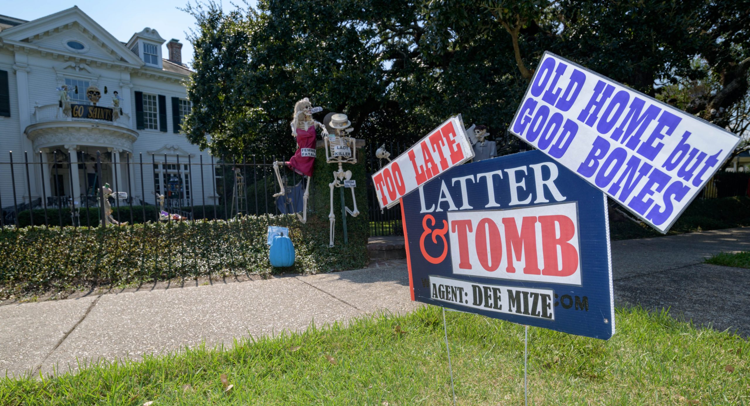 Louellen Berger sets up her annual parody skeleton garden on St. Charles Ave. and State Street in New Orleans on Monday September 30 and Tuesday October 1, 2019 with the help of Manuel Chacon. The pun-dead skeletons rib national and local celebrities and pop culture in an effort to tickle the funny bone. Berger hopes to have Dem Bones completed for viewing by later in the week and they will be on view through Halloween. She tends to keep the more colorful skeletons in the shade so they don’t fade in the sun. Once a few years back, Hurricane Nate was initially forecast to come through the area and she was on the fence on whether or not to take the display down for the storm. A family member suggested it won’t be good for recovery efforts after a storm for a random skull to be found in somewhere else in the city, so she took them down. Fortunately, the storm passed without incident. She says her grandchildren help come up with some ideas and the puns and funny sayings help the younger children learn language and idioms. Photo by Matthew Hinton