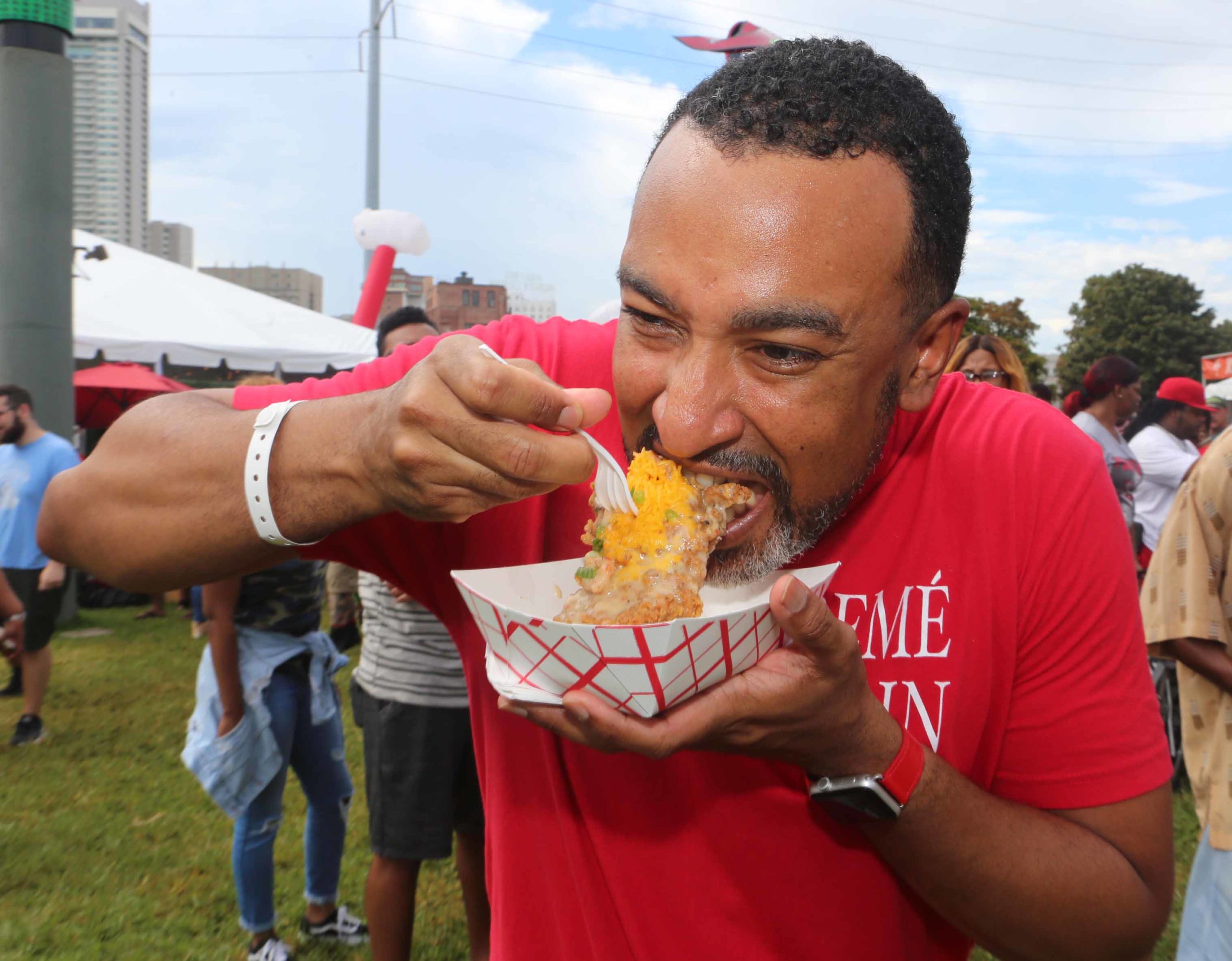 Nolan Marshall bites into some Bourbon Street Love (courtesy of Heard Dat Chicken) during the National Fried Chicken Festival at Woldenberg Park in New Orleans on Saturday, September 22, 2018.  (Photo by Peter G. Forest)  Instagram:  @forestphoto_llc