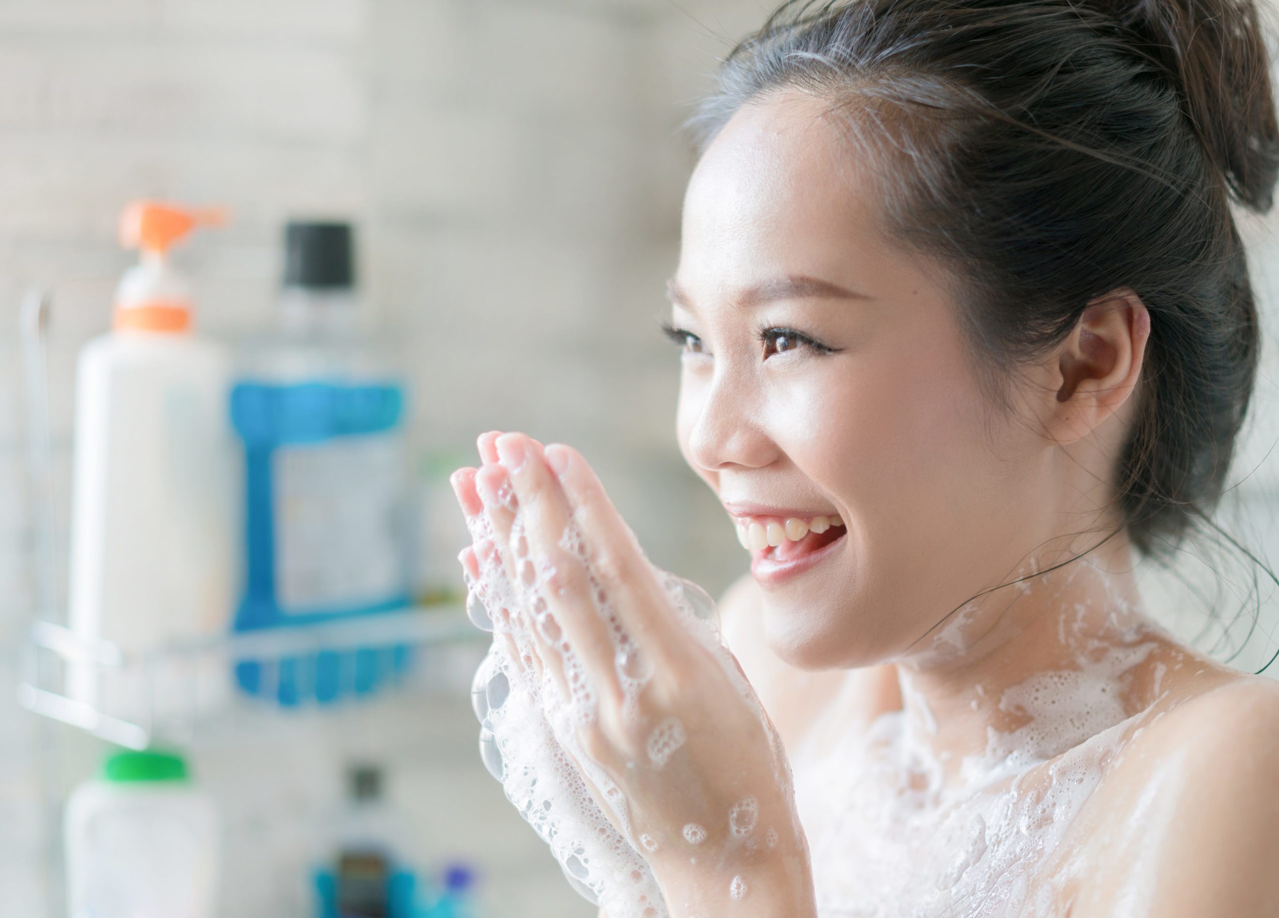 Asian women are taking a shower in the bathroom she is rubbing soap,she is happy and relaxed.