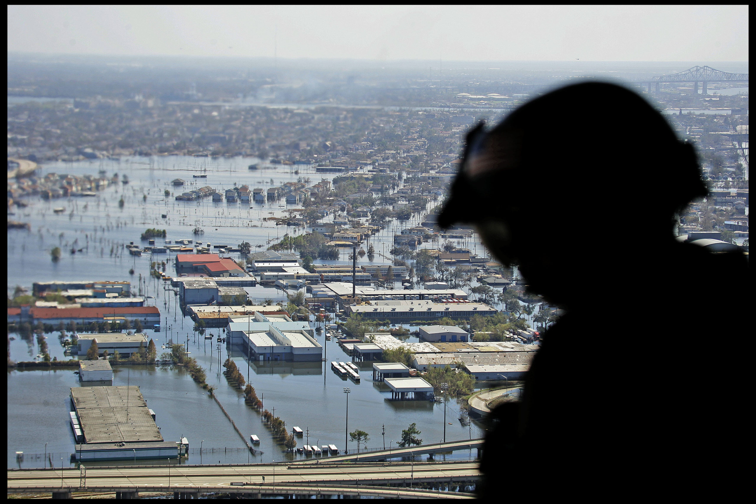 US Army loadmaster sits at the open back of a search and rescue chinook helicopter, while flying over a flooded New Orleans.  (Photo by David Howells/Corbis via Getty Images)