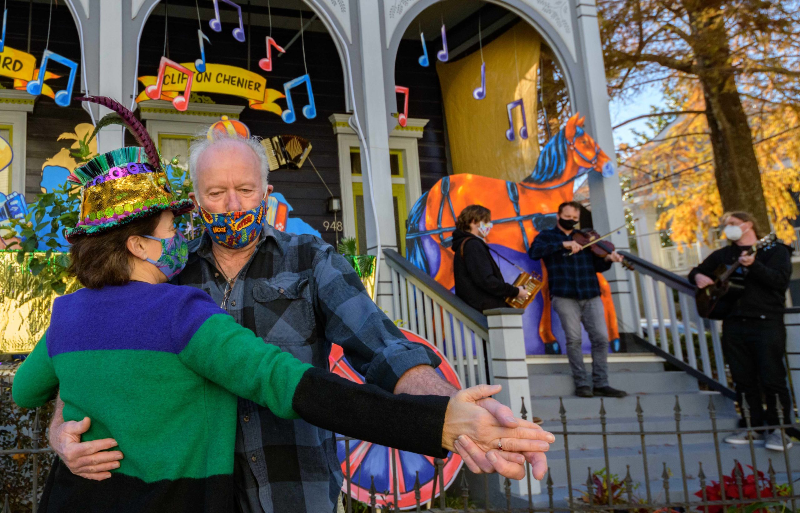 Michael and Stacey Burke to a three-piece Cajun band led by fiddler-singer Louis Michot of the Lost Bayou Ramblers in front of the “Acadiana Hayride” house float by “Hire A Mardi Gras Artist,” a grassroots initiative by the Krewe of Red Beans. The float features a horse-drawn hayride of Zydeco and Cajun music legends like Wilson Anthony "Boozoo" Chavis, D.L. Menard, and Clifton Chenier. A giant accordion that would take at least two people to play was put on the top of the home and was installed by Travis Keene, black jeans, and Joey Mercer, blue jeans, with a little help from Michael Burke. Burke is a retired gaffer or chief lighting technician for Law and Order SVU and Criminal Intent and he put his experience to work by lighting up the home at night.  The float wraps around to the other side with more notes and names of Cajun and Zydeco bands on the home on Euterpe Street in the Lower Garden District of New Orleans. The house float initiative hopes to build 40 house floats for every $15,000 donated. The donations go towards supplies and hiring float artists, many who are out-of-work because of the cancellation of Mardi Gras and Carnival parades due to the COVID-19 pandemic. Residents who live and own a home in Orleans Parish that donate to the project are entered into the raffle to get one of the house floats even for a small sum like $25. The #HouseFloat was designed by Caroline Thomas with additional artwork by Ryan Blackwood and Daniel Fuselier. Red Beans official photographer, @rhrphotography, even helped out in holding some of the artwork. Photos by @MattHintonPhoto for @VeryLocalNOLA #HireAMardiGrasArtist @Redbeansparade #KreweofRedBeans @c_to_the_line #NewOrleans #Louisiana #Carnival #neworleanslouisiana #nolalife #herenowlouisiana #gonola #onetimeinnola #itsyournola #showmeyournola #nola #followyournola #exploreneworleans #ilovenola #VLNOLA #kreweofhousefloats #mardigras2021 @kreweofhousefloats #LawandOrderSVU #vlnolamardigras #nbcsvu #svu @n