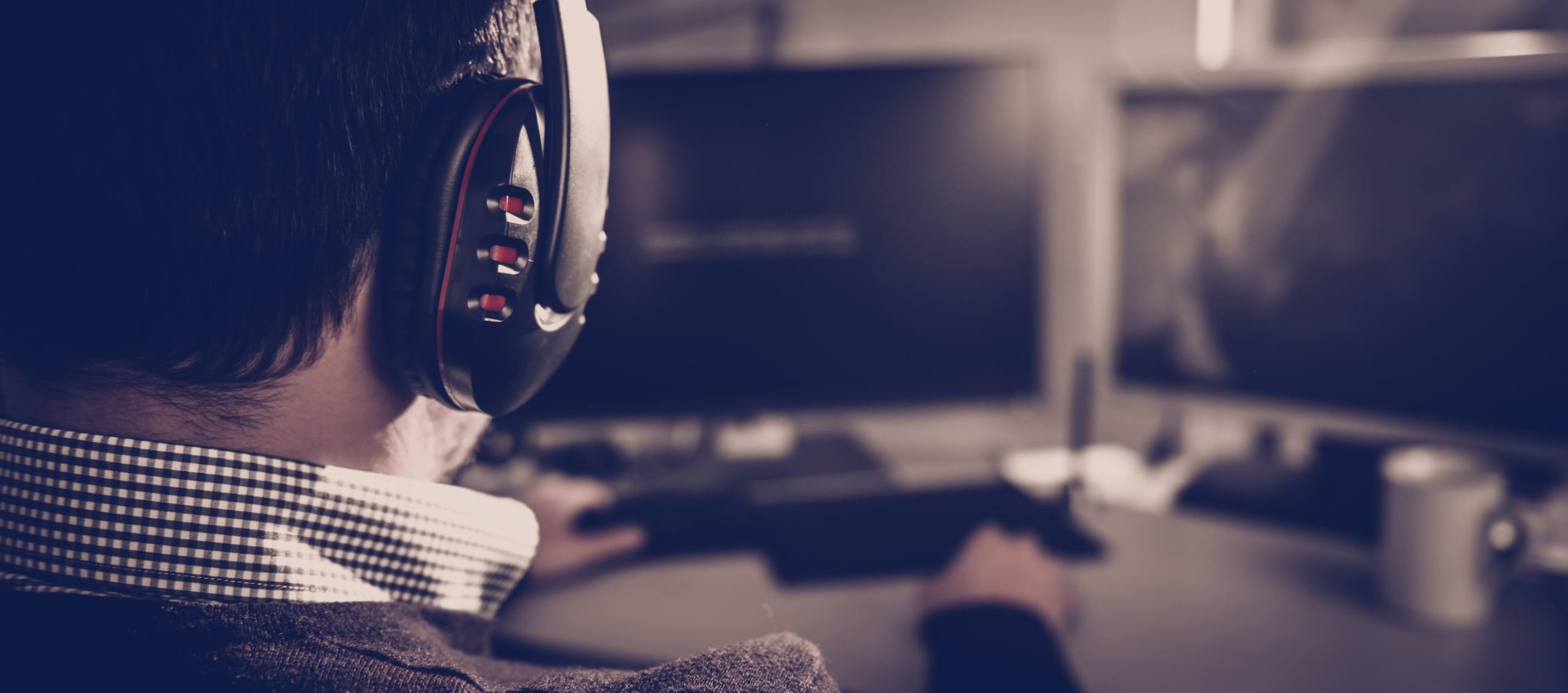 Man wearing headphones and playing video game